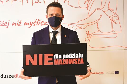 Mężczyzna w garniturze trzyma tabliczkę z napisem nie dla podziału mazowsza