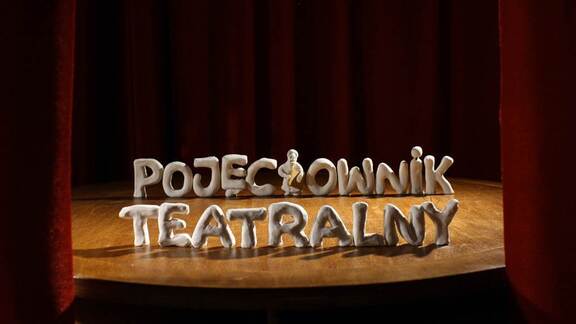 Scena teatralna z odsłoniętą kutyną. Na scenie ustawiono napis Pojęciownik teatralny.