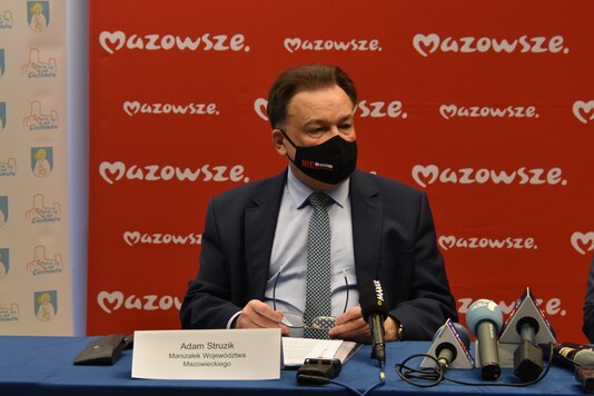 Marszałek na tle ściany z logo Mazowsza