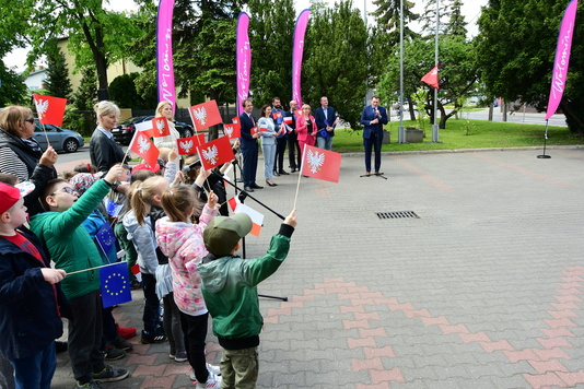 Grupa dzieci pozdrawia flagami przemawiających