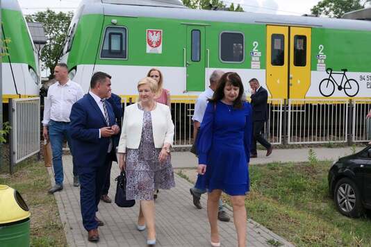 Uczestnicy uroczystości na tle pociągu