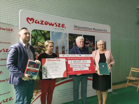 Pamiątkowe zdjęcie z symbolicznym, dużym czekiem