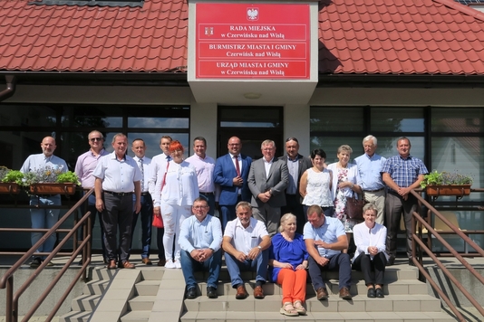 Zdjęcie grupowe uczestników posiedzenia Komisji Rolnictwa i Terenów Wiejskich na schodach przed ratuszem.