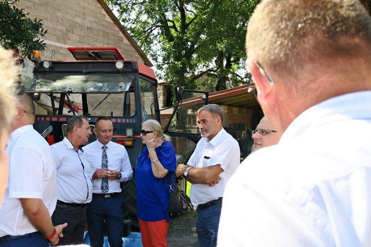 Radna Jadwiga Zakrzewska stoi wśród radnych Czerwińska i rozmawia, w jednym z wizytowanych gospodarstw.