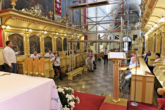 Radni siedzą w stellach prezbiterium czerwińskiego sanktuarium i słuchają kustosza.