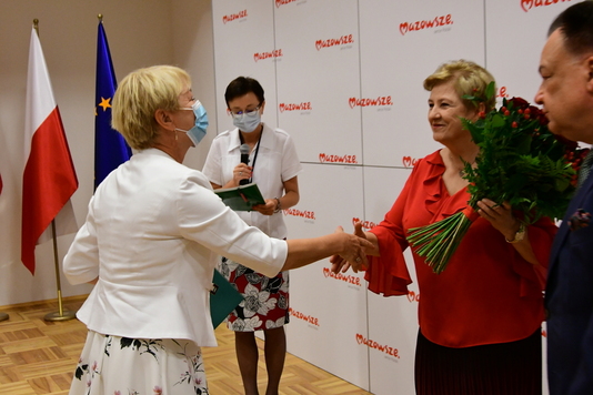 Kobieta kobiecie podaje bukiet róż