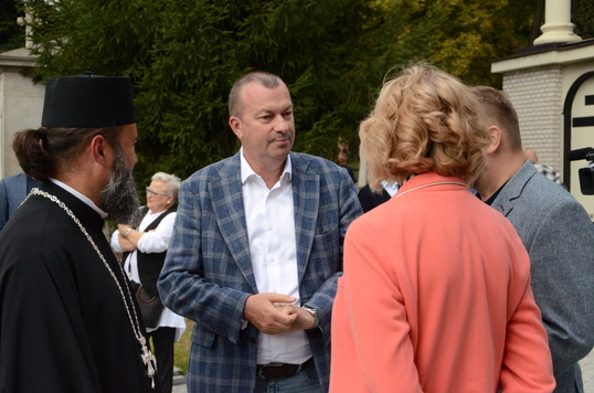 Elegancko ubrany mężczyzna rozmawia z kobieta po uroczystości wręczenia certyfikatu 