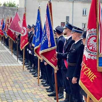 Strażacy sttojący w szereguy ze sztandarami