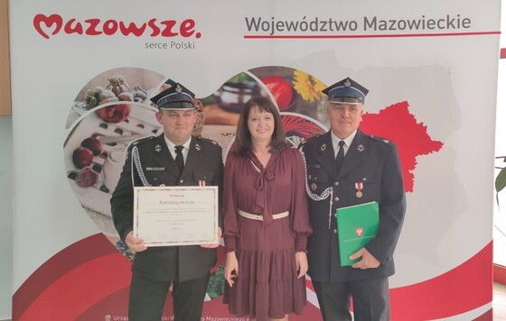 Zdjęcie pamiątkowe. Grupa osób na tle ścianki Mazowsze Serce Polski.