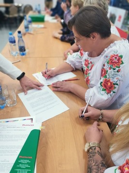 Zdjęcie pamiątkowe. Grupa osób na tle ścianki Mazowsze Serce Polski.