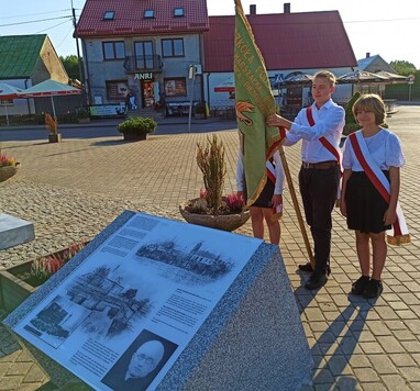 Młodzież ze sztandarem przy tablicy pamiątkowej