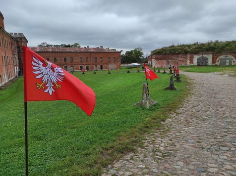 Wzdłuż ścieżki wewnątrz zabudowań twierdzy ustawione są chorągwie z godłem Mazowsza