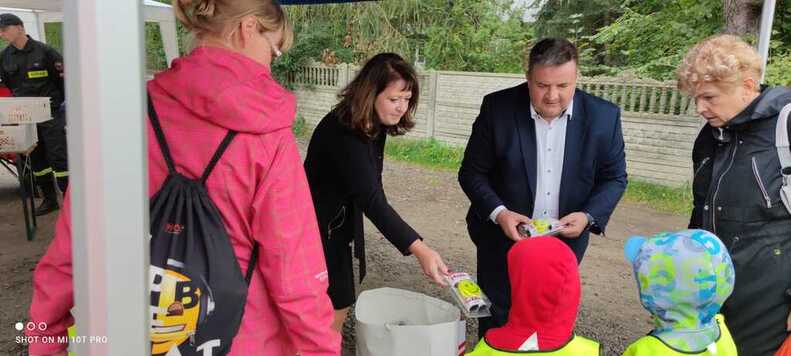  Kobieta wręcza dzieciom elementy odblaskowe