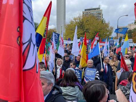 Przemarsz tłumu z kolorowtymi flagami