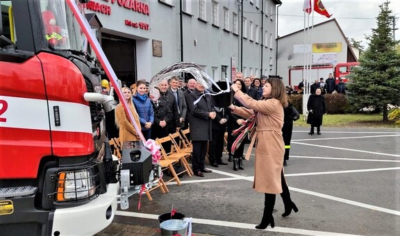 Janina Ewa Orzełowska polewa nowy wóz wodą z wiadra