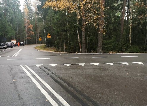 Puste, wyremontowana droga. Po obu stronach rośnie las