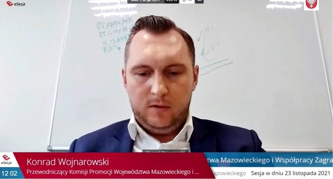 Printscreen z transmisji sesji sejmiku przedstawiający twarz Konrada Wojnarowskiego – przewodniczącego Komisji Promocji Województwa Mazowieckiego i Współpracy Zagranicznej