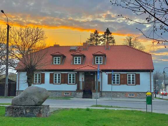 Widok na zabytkowy budynek muzeum na tle zachodzącego słońca