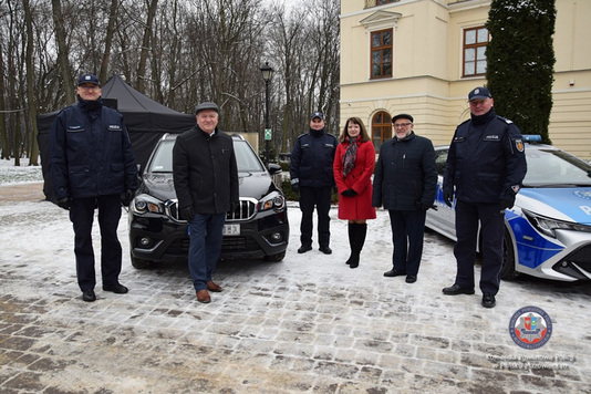 Janina Ewa Orzełowska, wraz z przedstawicielami komendy, stoi przed pałacem Dernałowiczów