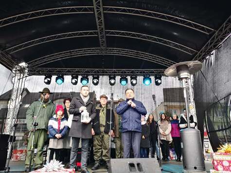 Marszałek i prezydent Ciechanowa stoją na scenie ustawionej na rynku. Marszałek trzyma w ręku mikrofon