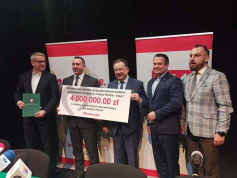 Pięciu mężczyzn stoi na tle ścianki promocyjnej