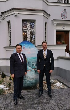 Marszałek i ambasador Chorwacji pozują do zdjęcia przed Ambasadą.