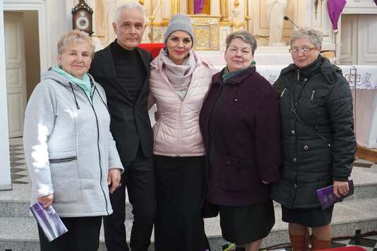 Widok na Dariusza Jakubowskiego z uczestnikami koncertu pasyjnego.