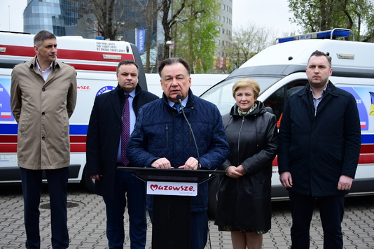 Na zdjęciu grupa kobiet i mężczyzn. Mężczyzna przemaiwa na konferencji