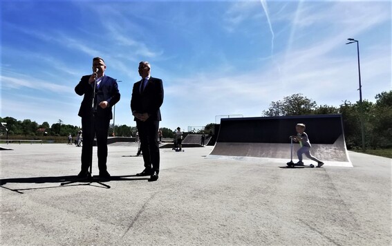 Wicemarszałek stoi na placu skateparku obok mężczyzny z mikrofonem