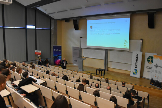 Widok z góry na uczestników konferencji naukowej.