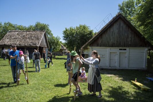 dzieci próbują stanąć na szczudłach