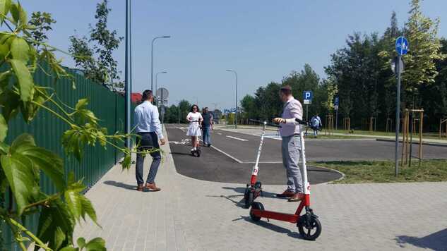 Dwie osoby poruszają się na elektrycznych hulajnogach. Testują nową nawierzchnię drogi