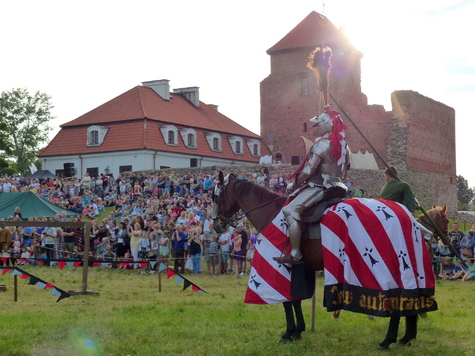 Widok na inscenizację turnieju rycerskiego. W tle widownia.