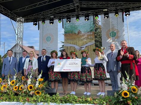 Członkinie KGW w Hadynowie stoją na scenie z symbolicznym czekiem