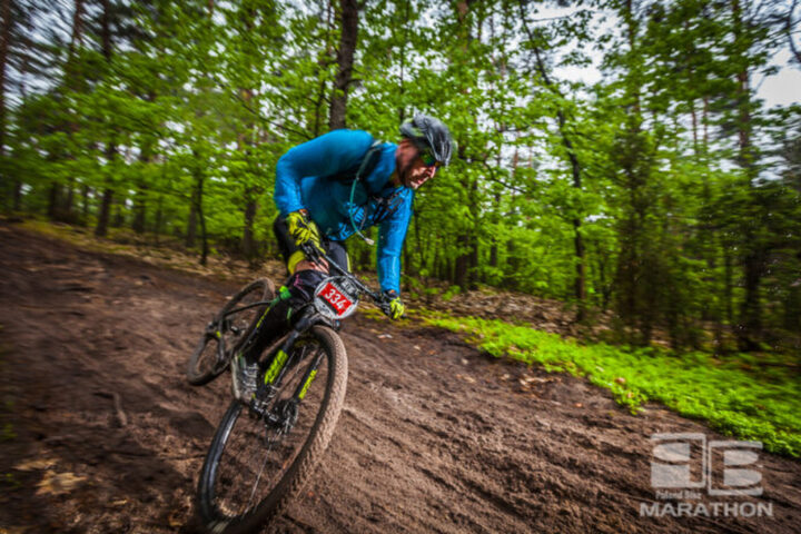 Rowerzysta w kasku jedzie stromą leśną ścieżką na rowerze mtb