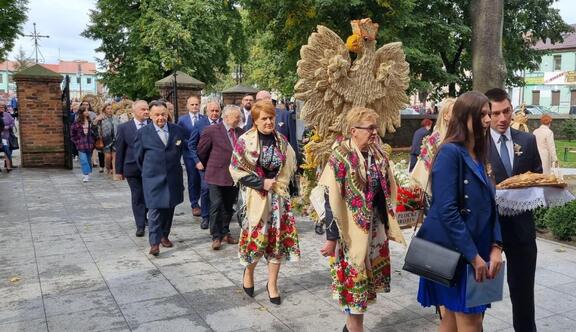 korowód dożynkowy. Na przodzie kobiety w ludowych strojach niosą wieniec w kształcie orła w Koronie. Za nimi, razem z innymi uczestnikami pochodu, idzie marszałek Struzik