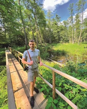 turysta z aparatem fotograficznym na ścieżce