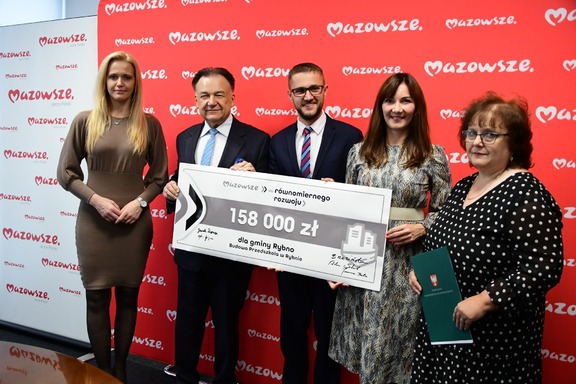 Marszałek, radne Brzezińska i Bala oraz beneficjenci pozują do zdjęcia z czekiem