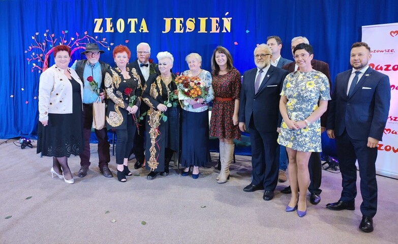 Janina Ewa Orzełowska pozuje do zdjęcia z seniorami