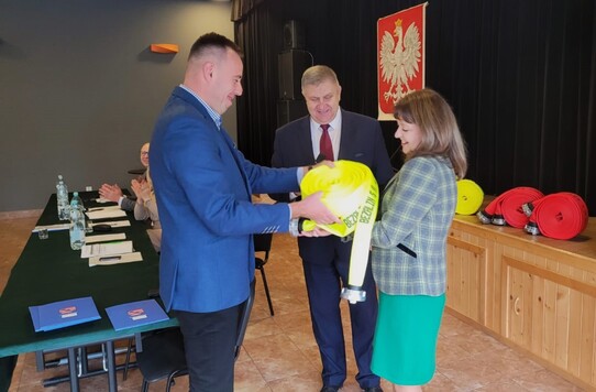 Orzełowska przekazuje wręcza strażakom sprzęt strażacki (wąż gaśniczy)