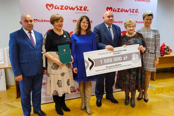 Członkinie zarządu pozują do zdjęcia z beneficjentami