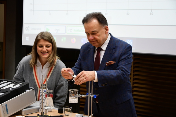 Marszałek uczestniczy w prezentacji doświadczenia chemicznego