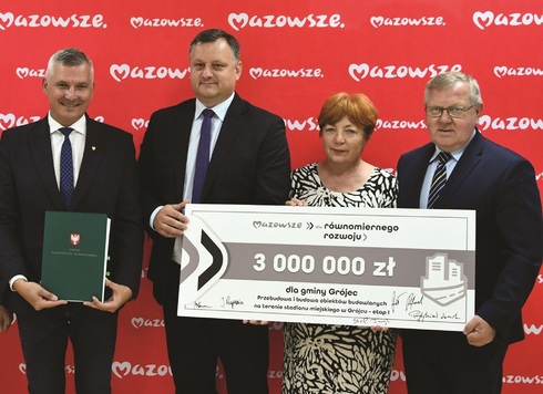 Podpisujący umowę stojący z czekiem