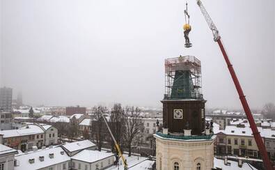 Dźwig umieszcza na ratuszowej wieży pomnik Atlasa.