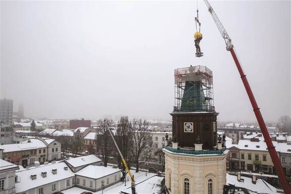 Dźwig umieszcza na ratuszowej wieży pomnik Atlasa.