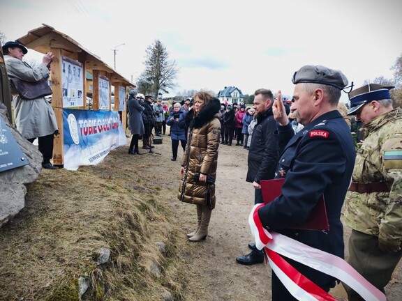 Orzełowska stoi przed pomnikiem Cichociemnych