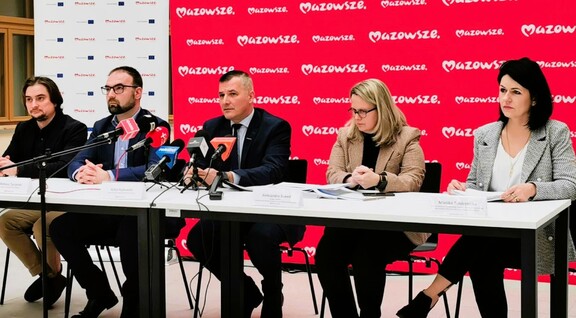 Pięć osób podczas konferencji prasowej na tle ścianki Mazowsze.