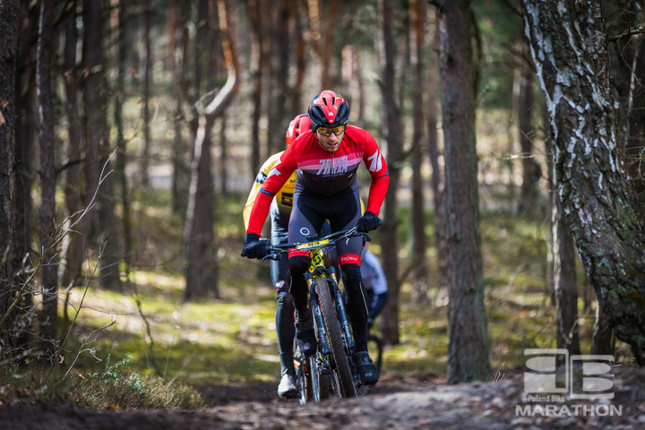 Kolarz na rowerze mtb pokonuje podejście pod górkę na leśnej ścieżce