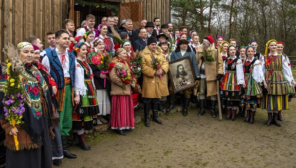 Grupa gości z palmami i obrazem Serca Jezusa przed kościołem