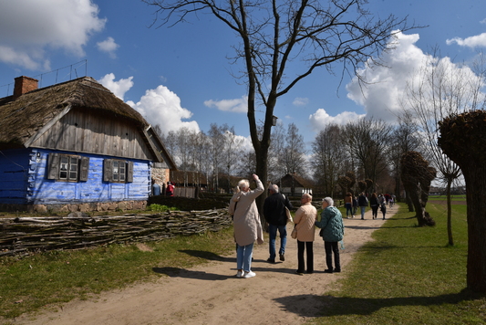 Ludzie spacerują po alejkach między chałupami